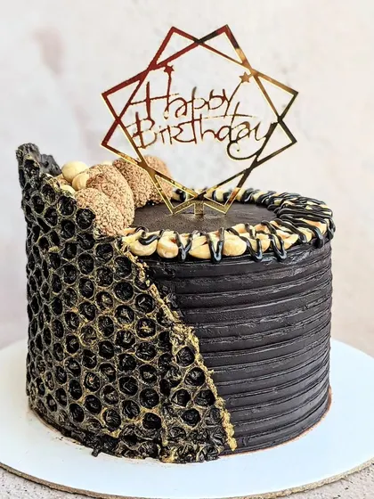 A decadent and modern Ferrero Rocher cake for a 16th birthday. I used a bubble wrap mold to create the unique gold-dusted chocolate collar, combining rich chocolate flavor with an edgy, textured design.