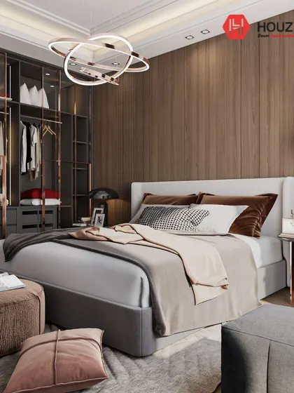 A modern bedroom featuring a walk-in closet with glass and rose gold frames. The combination of wood paneling and soft textiles creates a sophisticated and luxurious space for rest and organization.