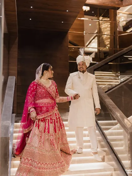 The newlyweds descending a grand, modern staircase hand-in-hand, a beautiful symbol of the start of their journey together.