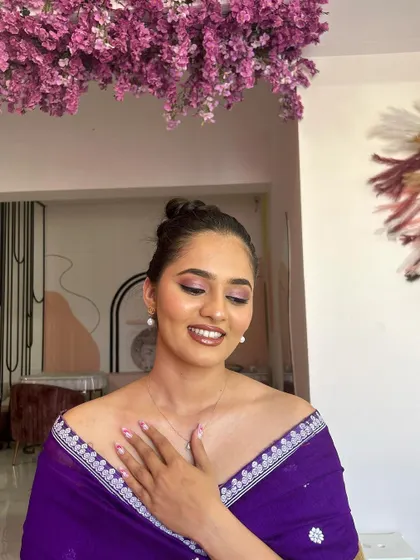A close-up of Leesha's makeup. The soft pink and purple tones on her eyes and her glossy lip create a fresh and modern look.