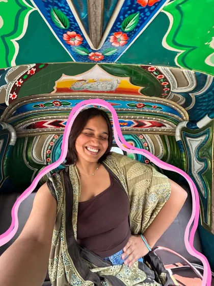 A happy selfie in a colorful auto-rickshaw, with a simple pink outline to make it pop.