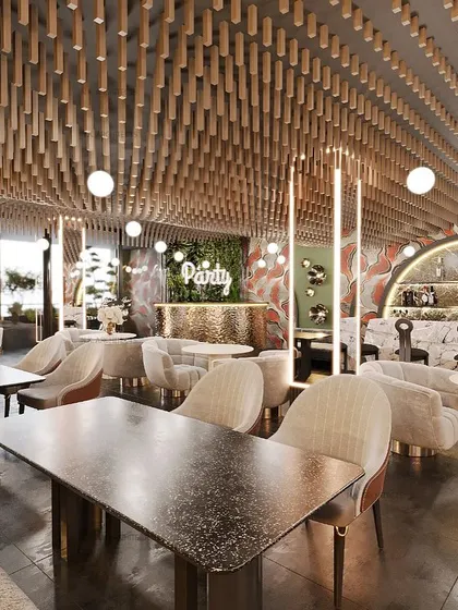 Another view of the Elation cafe, showing the party area with a green wall and custom bar. The design uses a mix of textures and lighting to create a warm and stylish atmosphere.