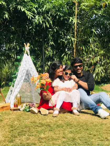 A mother and her two daughters smiling for a photo during their family picnic.