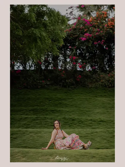 A beautiful solo portrait of the bride relaxing on a lush green hill.