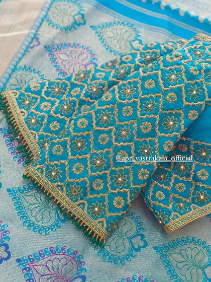 The sleeves of the teal blouse, showing the mirror work within the geometric pattern.