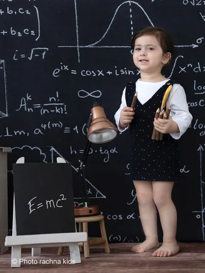 A standing portrait from the 'little professor' shoot, showing the full backdrop and props that create this academic setting.