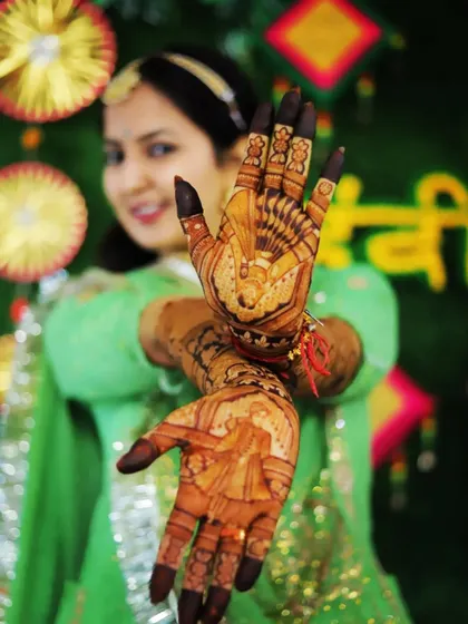 A beautiful bride posing with her hands, showcasing the intricate portraits on her palms.