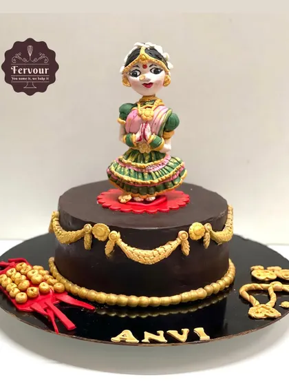 A full view of my Bharatnatyam dance-themed cake. The centerpiece is a detailed, hand-sculpted fondant dancer, surrounded by traditional elements like ghungroos, all on a rich chocolate truffle cake.