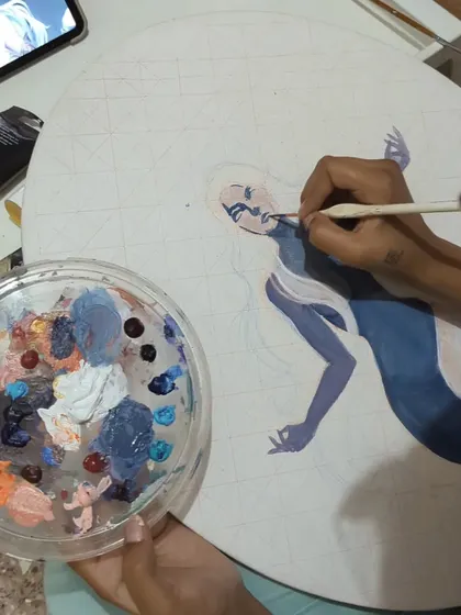 A close-up of my hands at work on a detailed canvas piece. You can see the fine brush I use for adding shadows and defining features, a process that requires a steady hand and lots of focus.