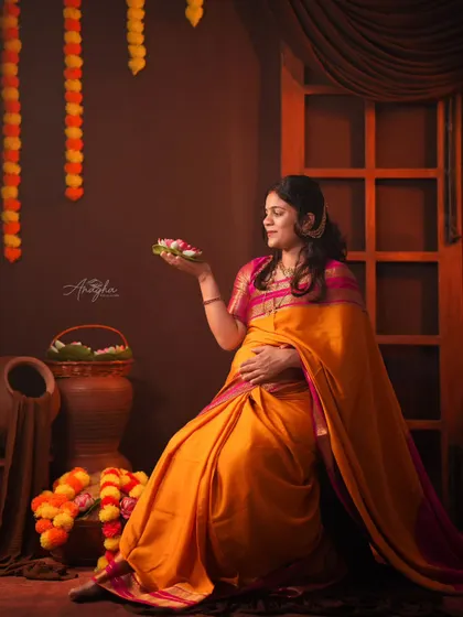 Holding a traditional offering, this mother-to-be is captured in a classic pose that celebrates our rich cultural ceremonies during pregnancy.