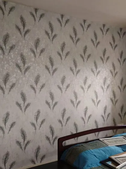Another bedroom with a grey feather pattern wallpaper, showing its versatility in different lighting and room layouts.