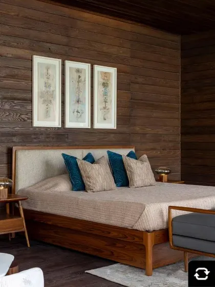 A prefabricated wooden bedroom suite featuring dark wood walls and a custom bed with an upholstered headboard. This design showcases our ability to create cozy, stylish sanctuaries using sustainable, factory-built components.