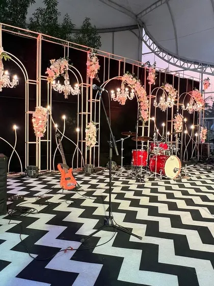 The stage is set for the evening's entertainment. This shot shows the instrument setup for the live band, highlighting the contrast between the modern chevron floor and the romantic, chandelier-lit backdrop.