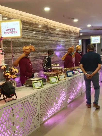 A view of our sweet counter and main course line at a wedding reception. The clear signage and organized layout ensure a smooth experience for all guests.