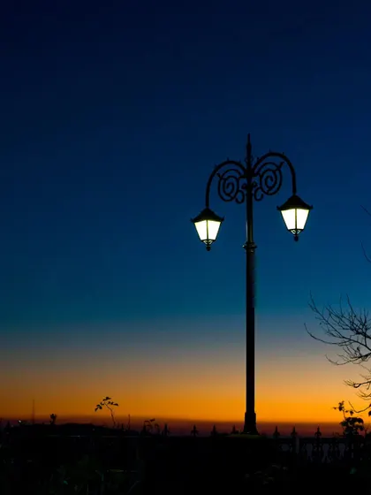A classic Victorian-style lamppost silhouetted against the twilight sky in Shimla.