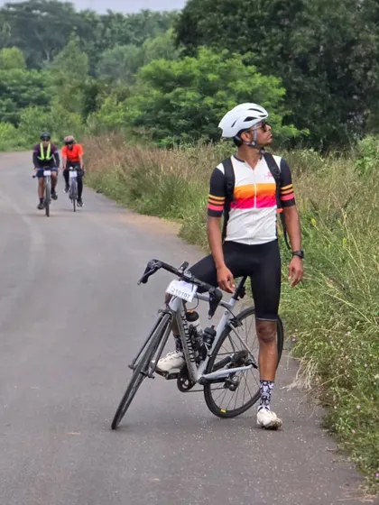 Another rider enjoying the view on a quiet, tree-lined road during the Rajyotsava 200k ride. It's not just about the distance, but also the journey.