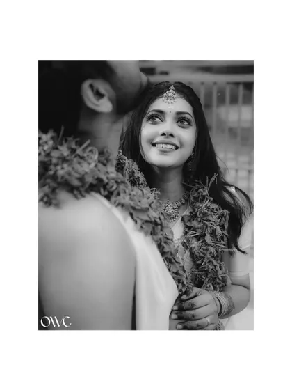 A beautiful black and white over-the-shoulder shot of a bride looking up at her groom with adoration.