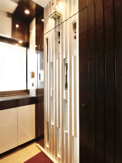 The closed safety door, showcasing its modern design with offset vertical slats. The entrance area also includes a built-in shoe cabinet, demonstrating my focus on integrating storage from the very first step into the home.