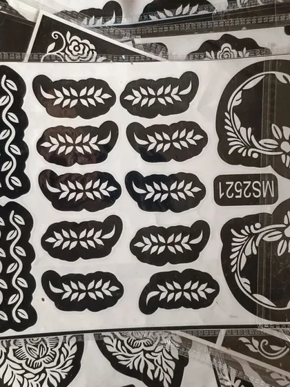A stencil sheet with delicate vine and leaf patterns. These are perfect for creating borders or adding small details to your henna design.