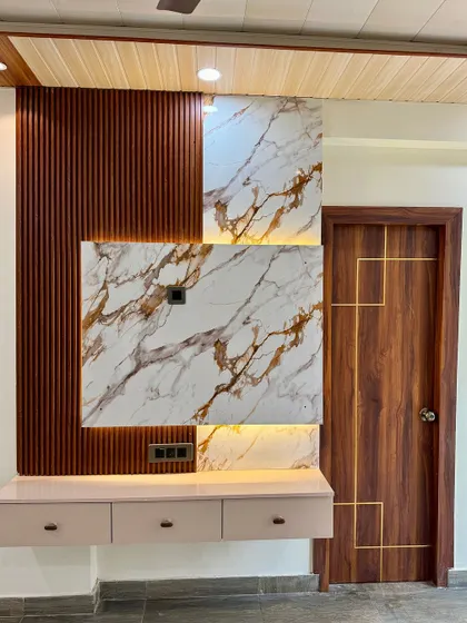 This image shows a TV unit next to a flush door with custom gold inlay work, creating a cohesive and luxurious look.