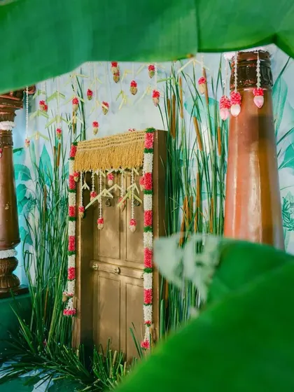 This close-up captures the artistry of the decor, from the floral garlands to the traditional pillars, all set against the custom-painted wall.
