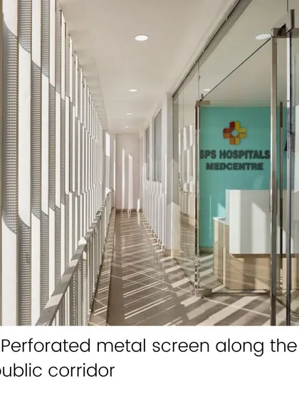 The perforated metal screen along the public corridor of the SPS Clinic filters natural light, creating dynamic patterns of light and shadow. This feature provides privacy while enhancing the aesthetic experience of the space.