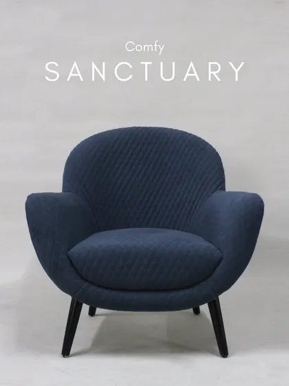 This comfy sanctuary armchair in a quilted navy fabric is perfect for curling up in. Its rounded shape and deep seat provide a sense of being enveloped in comfort.