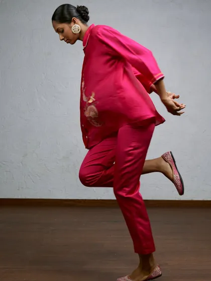 A playful, mid-motion shot that captures the fun and vibrant energy of this bright pink outfit. This kind of dynamic image is great for social media and campaigns, showing the clothing in a lively, engaging way.