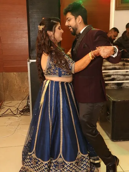 A candid moment of joy. This couple dances the night away, with her in a stunning rented blue lehenga.