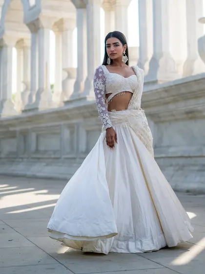 Another piece from our Ivory Edit. This stunning lehenga-saree features a single embroidered sleeve and a dramatic, flowing skirt.