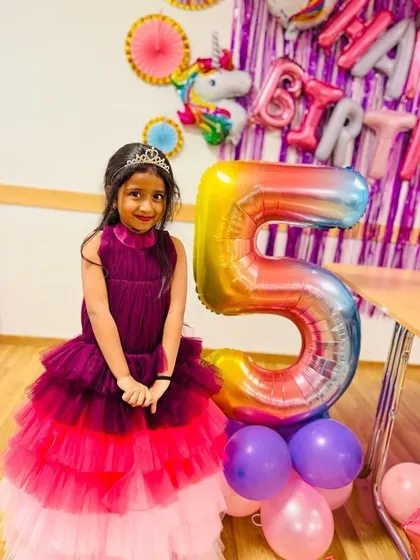 Two sisters celebrating their birthdays together in matching tiered gowns. The older sister is turning five.
