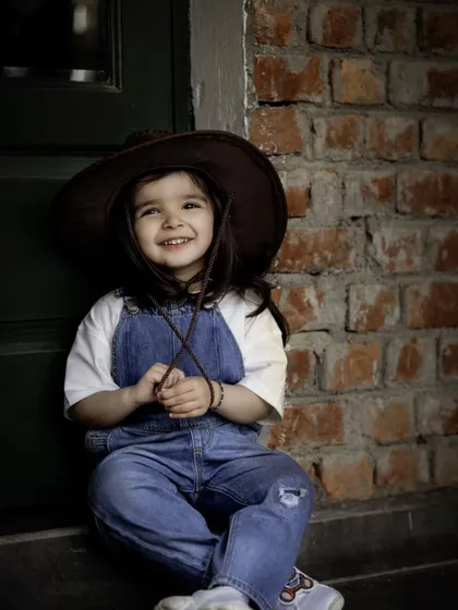 A quiet moment with a gentle friend. This shot from our cowgirl-themed outdoor shoot captures the sweet and trusting bond between a child and an animal.