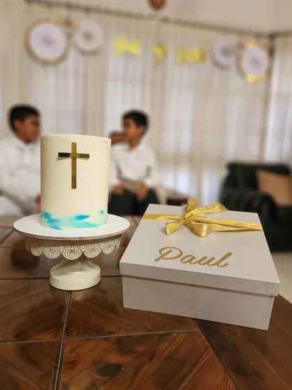 A tall, minimal Holy Communion cake with a simple gold cross and a touch of blue watercolor. This design is modern, elegant, and perfectly suited for a sacred occasion.