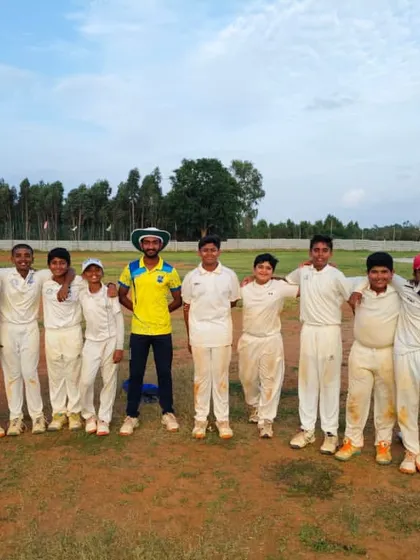 The team stands with their coach, united and proud in their cricket whites.