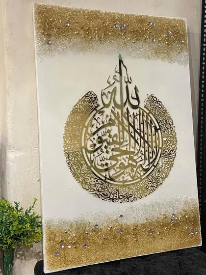 An elegant Ayat al-Kursi artwork in white and gold, with a delicate balance of calligraphy and textured borders.