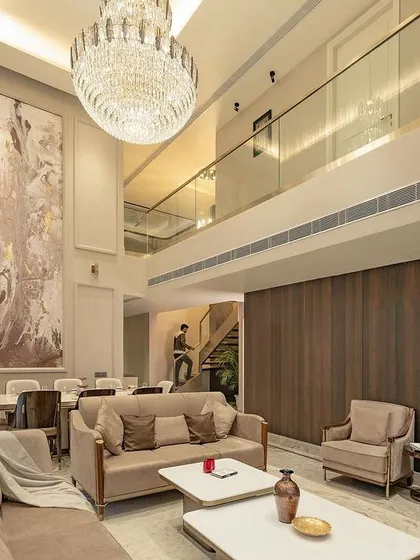 We believe in creating spaces with presence. This double-height drawing room uses vertical volume, a statement chandelier, and a neutral palette to create an atmosphere of classical opulence and refined comfort.