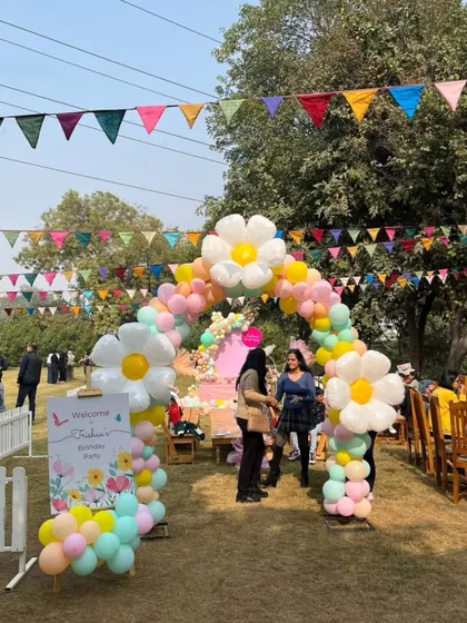 Guests arriving at a party with a stunning daisy balloon arch, showcasing the grand entrance we can create for your event.