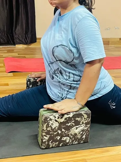 A close-up of using blocks for support in a split. This technique allows the student to relax into the stretch without straining, leading to greater long-term flexibility.