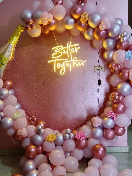 A "Better Together" themed celebration with a pink and silver balloon ring and a champagne foil balloon.