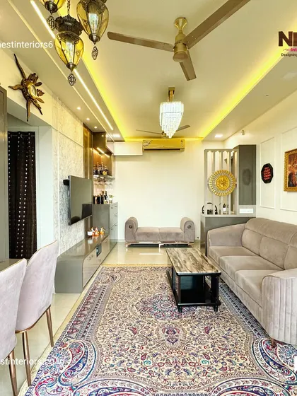 A full view of the living area, showcasing the combination of a large patterned rug, modern furniture, and decorative pendant lights to create a luxurious and inviting atmosphere.