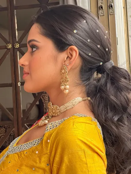 A chic and playful pearl-studded ponytail. This is a perfect hairstyle for a Haldi or Mehendi, keeping you cool while looking incredibly stylish.
