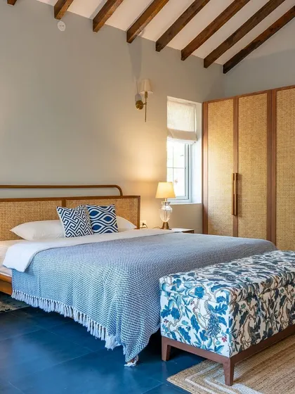 A bedroom in our Goa project, featuring a custom bed with a rattan headboard and a matching wardrobe. The design captures the relaxed, tropical vibe of the location.