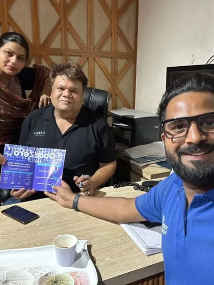 Our team with a couple at their desk, holding our "GoodZero" brochure. We provide clear information on savings.