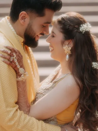 The pure, unscripted joy of a Haldi ceremony. This close-up captures a genuine smile and the beautiful details of the moment, from the floral jewelry to the shared laughter.