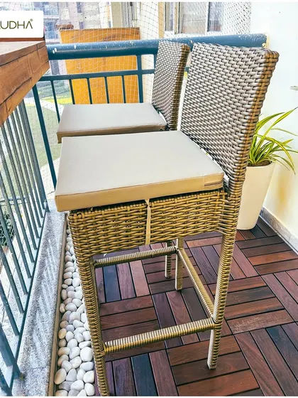 Coordinating furniture is key to a striking balcony. This set of images shows a project where we used matching wicker furniture, including a sofa, chair, table, and bar stools, to create a cohesive and stylish look.