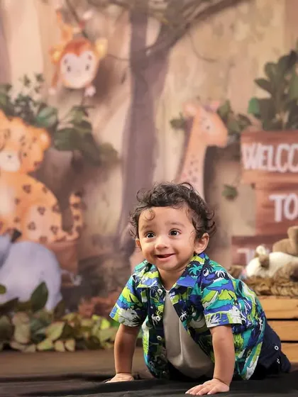 Look at that happy little explorer! Sitter sessions, for babies around 6 to 9 months, are perfect for capturing their budding personalities. This jungle theme, with its friendly animals and lush backdrop, is a client favorite for adventurous little ones.
