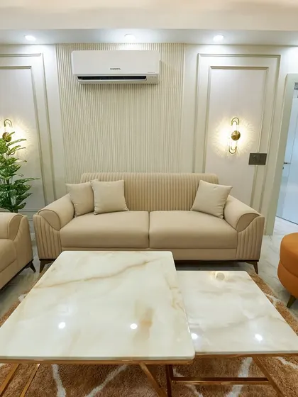 A different angle of the elegant living room, highlighting the comfortable sofas and the warm glow from the wall sconces. This is a perfect space for relaxation.