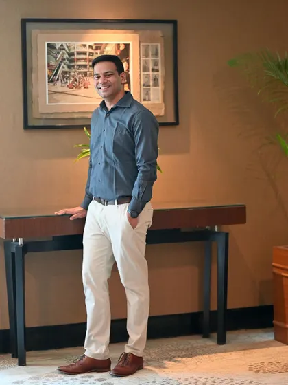 A smart-casual look for a matrimonial profile. This full-length shot in a modern setting shows a confident and contemporary lifestyle.