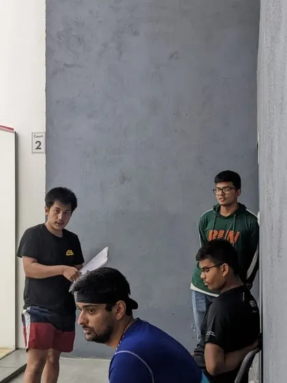 The atmosphere at our tournaments is a mix of focus and camaraderie as players watch and wait for their turn on the court.