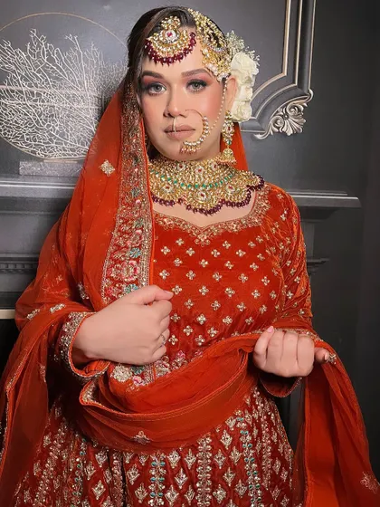 Another angle of the orange velvet outfit, showing the drape of the dupatta.